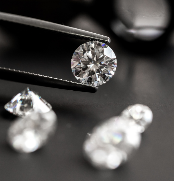 Natural diamond held with precision tweezers during expert quality inspection